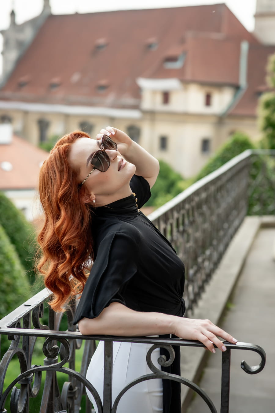 Vivien Arden v elegantních šatech na schodišti historické zahrady